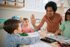 Happy,African,American,Teacher,And,Small,Boy,Giving,High-five,During