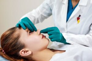 lady with plaster nose doctor examining patients face after plastic surgery